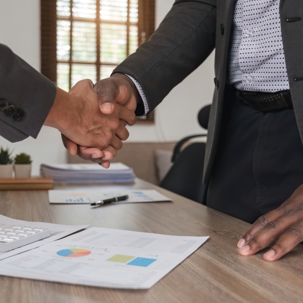 Close up of african business man and asian man shaking hands while at the office Close up of african business man and asian man shaking hands while at the office.